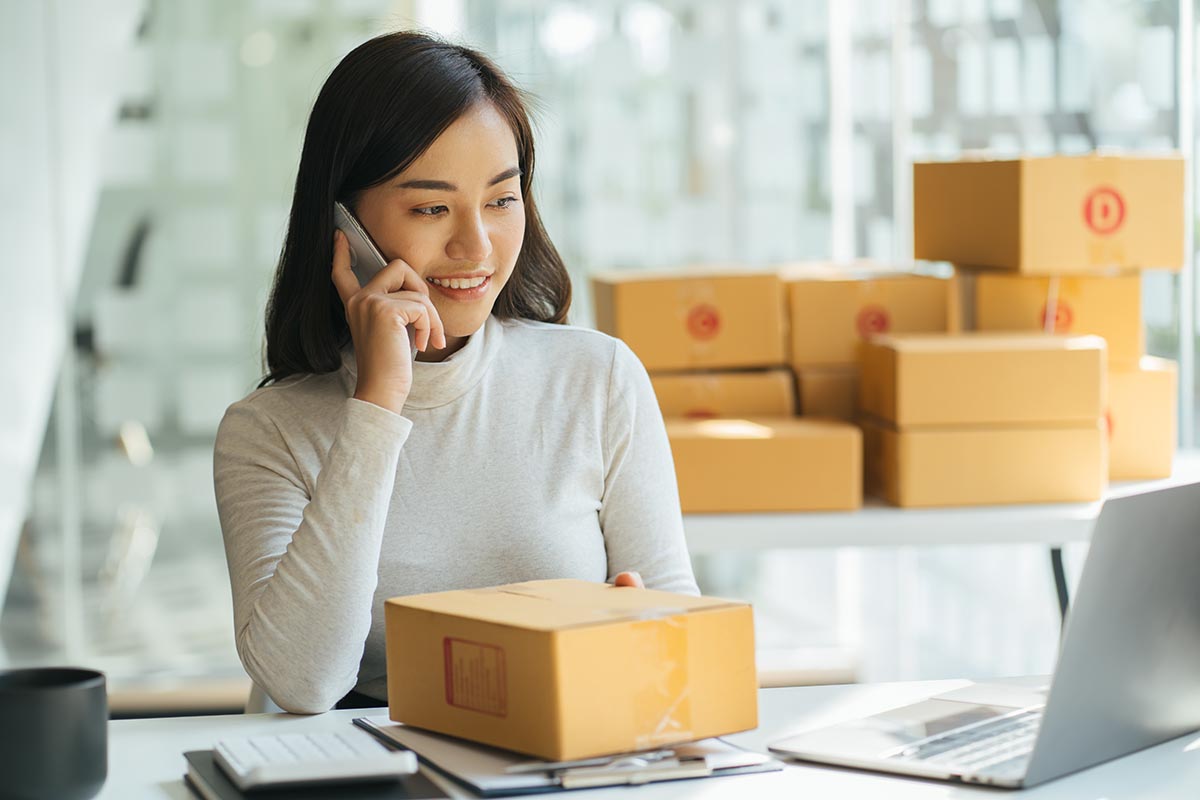 Portrait young attractive asia female owner startup business look at camera work happy with box at home prepare parcel delivery in sme supply chain, procurement, omnichannel commerce online concept.